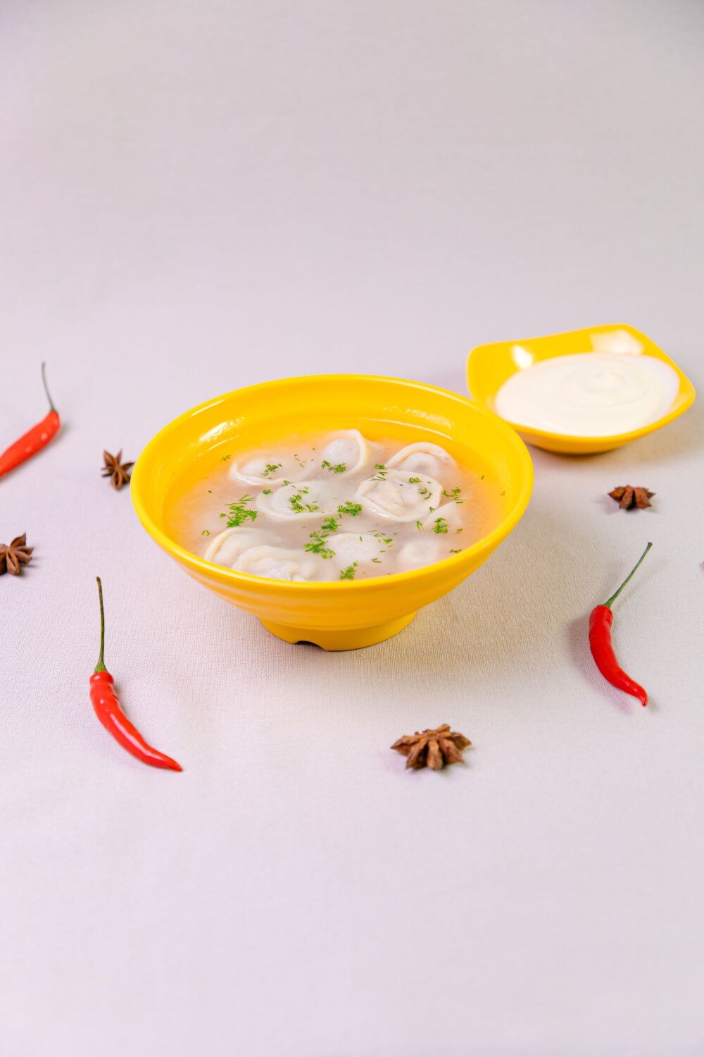 Пельмени с бульоном и сметаной